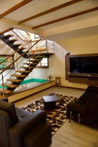 a living room with a staircase and a tv at Villa Oasis cafetero in La Tebaida