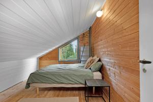 une chambre avec un lit dans un mur en bois dans l'établissement Fjord Nest By Stavanger BnB 29, à Stavanger