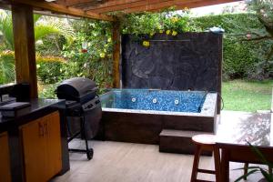 a hot tub in a backyard with a grill at Villa Oasis cafetero in La Tebaida