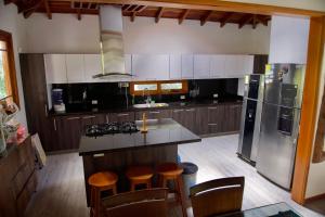 a kitchen with a island with stools in it at Villa Oasis cafetero in La Tebaida