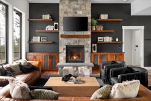 a living room with a couch and a fireplace at Luxe Lakeside New Build by Flathead Lake Speakeasy in Somers