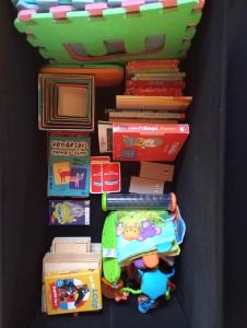 une pile de jouets et de livres sur une étagère dans l'établissement Les Chalets de Parly, à Parly 6 autres photos