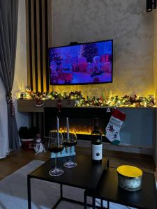 a living room with two glasses of wine and a fireplace at Apartman Njegoš Lux Titova vila in Palisad