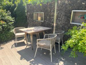 a table and chairs on a patio with a stone wall at REST - Ferienwohnung "Sonnenblume" mit schönem Bergpanorama - ab Mai Chiemgaukarte NEU! in Siegsdorf +10 photos