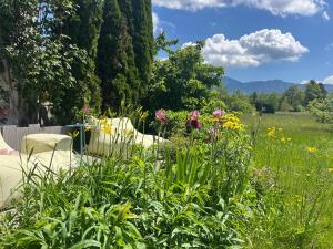 a garden with a table and chairs and flowers at REST - Ferienwohnung "Sonnenblume" mit schönem Bergpanorama - ab Mai Chiemgaukarte NEU! in Siegsdorf
