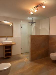 a bathroom with a toilet and a sink and a shower at REST - Ferienwohnung "Sonnenblume" mit schönem Bergpanorama - ab Mai Chiemgaukarte NEU! in Siegsdorf