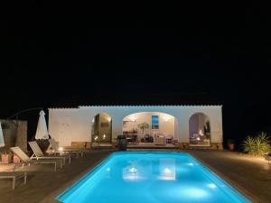 a large swimming pool in a yard at night at Quinta do Mastim in Évora
