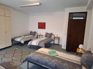 een kamer met drie bedden erin met een deur bij Gästezimmer 2 in Mönchengladbach