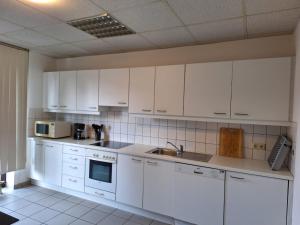 een witte keuken met witte kasten en apparaten bij Gästezimmer 2 in Mönchengladbach