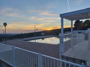 a swimming pool on top of a building with the sunset at Jolie petite Maison, Clim, résidence avec piscine à 5mn circuit Paul Ricard in Le Castellet