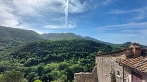 a view of a valley with mountains and a building at Cottanello,"La casa del sole" in Cottanello