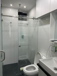 a bathroom with a toilet and a glass shower at Penthouse lujo, Parque La Carolina, Piscina, parqueo 3 habitaciones in Quito