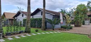 a house with a garden with palm trees at Familien Haus Pousada in Pomerode