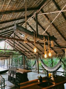 ein Pavillon mit Tischen und Stühlen und einer Hängematte in der Unterkunft Vila Ypáwa 150 m centro 30 m praia lago verde in Alter do Chao + 145 Fotos