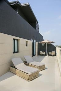 un patio con 2 tumbonas y una sombrilla en Elite Residence, en Accra