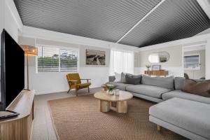 a living room with a couch and a tv at Settlers Cottage and Settle Inn in Broadwater