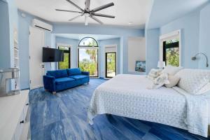 a blue bedroom with a bed and a blue couch at Ocean Depth Room at Barnacle Resort in Big Pine Key
