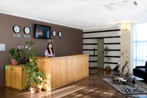 a woman standing at a reception desk in a room at Hotel & Fitness Center MANDARIN in Aktau