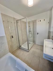 ein Badezimmer mit Dusche, Badewanne und Waschbecken in der Unterkunft 1904 - Am Kurpark in Dahme