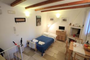 a bedroom with a bed and a desk with a computer at La Casetta Nel Vico in Polignano a Mare