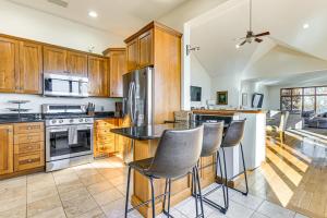 Una cocina con gabinetes de madera y una isla con taburetes de bar. en Waterfront Home with Boat Dock and Deck in Storm Lake!, en Storm Lake
