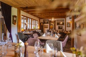 a restaurant with wooden tables and chairs and windows at Hotel-Restaurant Eifeler Seehütte in Rieden