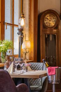 a room with a table with a grandfather clock at Hotel-Restaurant Eifeler Seehütte in Rieden +14 photos
