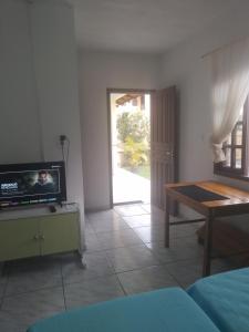 a living room with a tv and a table at Simplesmente aconchegante in Itapoa
