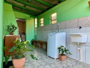 a green room with a refrigerator and some plants at Casa Privativa com Varanda Gourmet e Churrasqueira- Pet Friendly- Wi-Fi e Garagem in Imbituba
