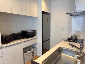 a kitchen with a sink and a microwave at n6天花 in Niseko +15 photos