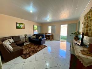 a living room with a couch and a table at Casa Privativa com Varanda Gourmet e Churrasqueira- Pet Friendly- Wi-Fi e Garagem in Imbituba