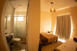 a bathroom with a bed and a toilet and a sink at Residencial Beija-Flor in Palhoça +12 photos