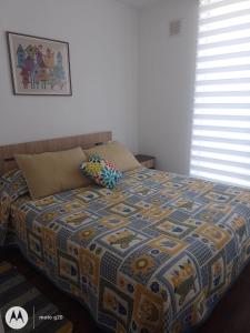 un letto con una trapunta in una camera da letto di Departamento en Pucón a Pucón