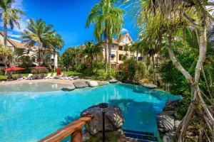 Cairns NorthにあるElevated 2BR Modern Furnished Terrace Apartmentのヤシの木と家のスイミングプール