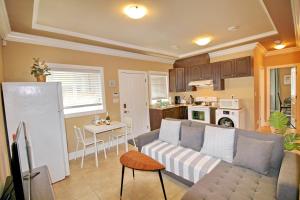 a living room with a couch and a kitchen at Close to YVR King Sized Private Entrance Suite in Richmond