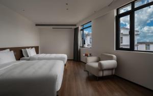 a bedroom with two beds and a chair and a window at Neo-garden in Dali