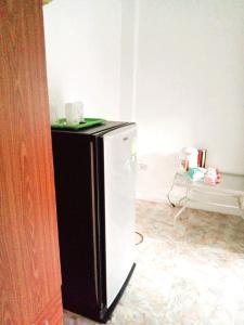 ein schwarzer und weißer Kühlschrank in einem Zimmer in der Unterkunft Khum Khun Phon Resort Khao Yai in Nong Nam Daeng