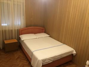 una piccola camera da letto con un letto con lenzuola bianche di Apartments by the sea Drasnice, Makarska - 23448 a Drašnice