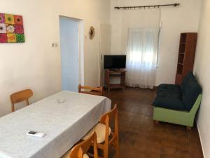una camera con tavolo, divano e TV di Apartments by the sea Drasnice, Makarska - 23448 a Drašnice
