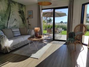a living room with a couch and an umbrella at Gîte in Etretat near Cliffs & Beach in Bordeaux-Saint-Clair