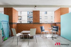 シドニーにあるMetaWise 2Bed on Dixon Next to ICC & Darling Harbour 65のレンガの壁、パティオ(テーブル、椅子付)