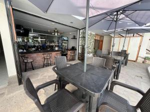a patio with a table and chairs and a bar at HOTEL AREQUIPA in Nazca