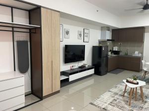 a living room with a television and a kitchen at Amir's Cozyhouse Seksyen14 -WIFI & NETFLIX- in Shah Alam +3 photos