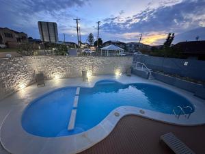 a large blue swimming pool with a stone wall at Venus Resort in The Entrance