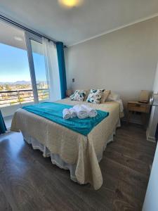 a bedroom with a bed and a large window at Depto hermosa vista al Lago y Volcán in Villarrica