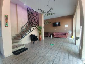a living room with a staircase and a pink couch at PH BOUTIQUE HOTEL Girardot in Girardot