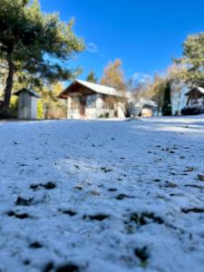 a snow covered yard with a house in the background at La Villa del Barone in Predaia