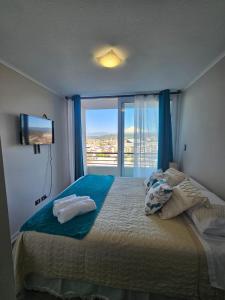 a bedroom with a large bed with a large window at Depto hermosa vista al Lago y Volcán in Villarrica +7 photos