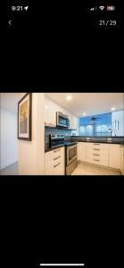 a kitchen with white cabinets and a large window at Luxury - Ocean front - 3 Bedroom 2 Bathroom - Penthouse in Miami Beach