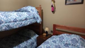 a bedroom with two beds with blue and white sheets at Casa Pucon in Pucón